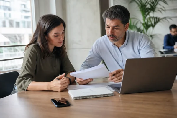 Equipo comercial en oficina española revisando oportunidades con agentes de ia en ventas y notas impresas