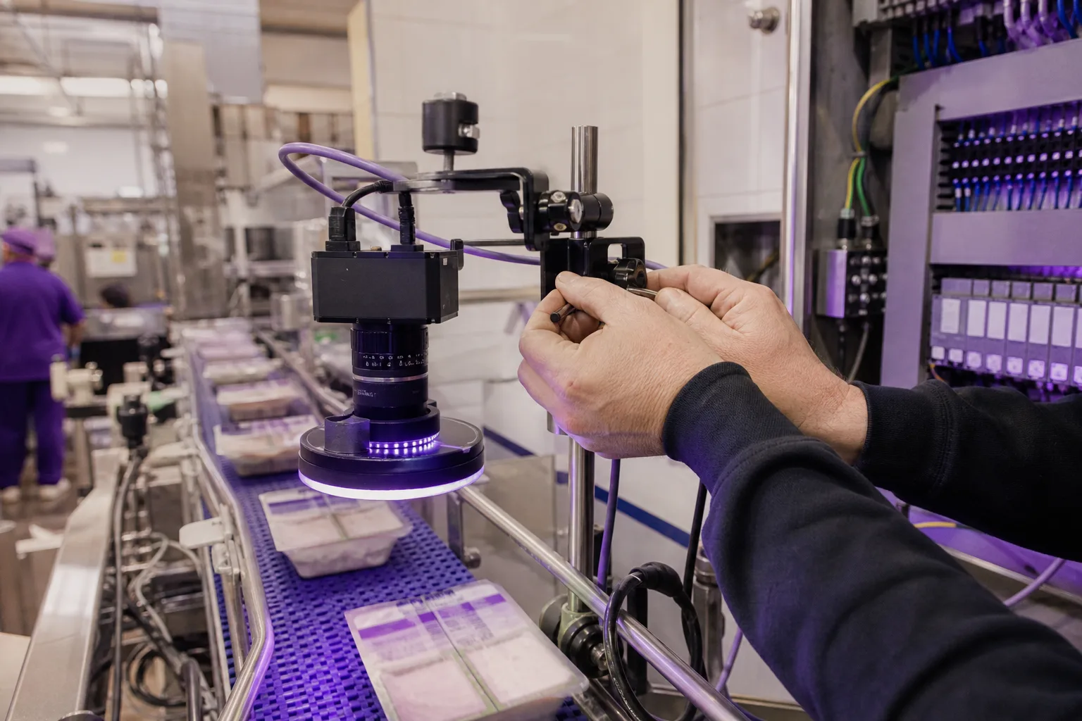 Detalle de cámara e iluminación industrial sobre una cinta de producción preparada para control de calidad